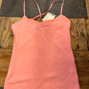 Rosa linnetopp från Zara - Säljer en söt rosa linnetopp från Zara med tunna axelband. Perfekt för varma sommardagar. Toppen är enkel och stilren, vilket gör den lätt att matcha med olika outfits. Korsade band i ryggen! Helt ny med lapparna kvar🩷🩷