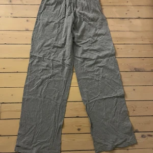 Grå mjukisbyxor från ASOS Design - Säljer ett par grå pyjamasbyxor från ASOS Design. Byxorna har en loose passform med elastisk midja och snörning för extra komfort. Använda fåtal gånger. Långa i benen på mig som är 177. Pris kan diskuteras!🥰
