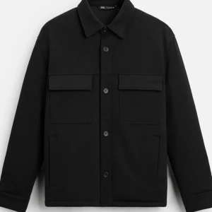 Svart overshirt från Zara - Säljer en stilren svart overshirt från Zara. Jackan har långa ärmar och knappar framtill. Den är perfekt för lager-på-lager och har två stora fickor på bröstet. Passar bra till både vardag och mer uppklädda tillfällen. Nypris 699kr, knappt använd