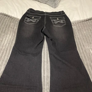 Svarta jeansbyxor från Shein Curve - Snygga svarta jeansbyxor från Shein Curve med dekorativa bakfickor och kontrastsömmar. Byxorna har en bootcut-stil som ger en trendig look. 