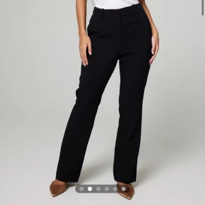 Svarta kostymbyxor - Eleganta svarta kostymbyxor (Vilma)med hög midja och rak passform. Perfekta för en stilren look. Byxorna har en klassisk design med dragkedja och knappar framtill. Strl 42 men sitter som 40 💕