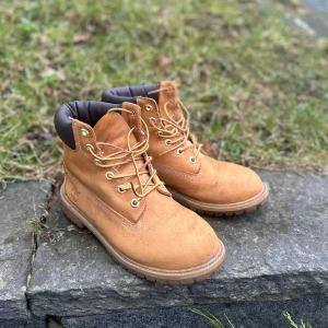 Kängor från Timberland - Säljer ett par klassiska kängor från Timberland i skinn. Tecken på använding men i bra skick! Inköpta för många år sen i USA men har tyvärr tvingats inse att de är för små för mig. Storleken är 6M och är köpta på junioravdelningen, passar en storlek 38-39. 