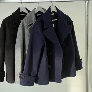 Mörkblå kappa med knappar - Supersnygg mörkblå kappa med bred krage och dubbelknäppning. Jackan har långa ärmar med dekorativa knappar vid ärmsluten. Perfekt för en stilren look. Den har blivit något noppriga men inget som märks på. Storlek xs/s och nypris 757kr