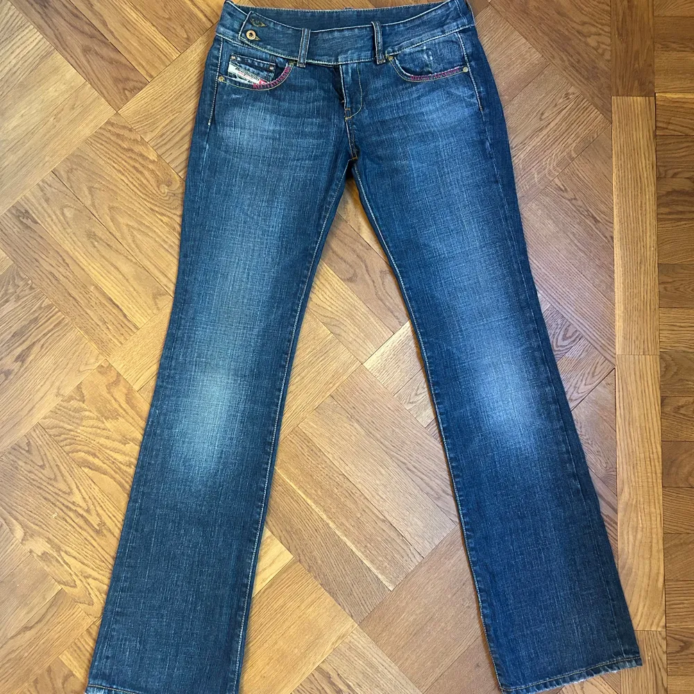 Säljer ett par snygga blå jeans från Diesel. De har en bootcut-stil och är lågmidjada. Jeansen har coola detaljer som kontrastsömmar och en liten ficka med Diesel-logga. Köpta secondhand i Köpenhamn! Innerbenslängd: 87 cm. Jeans & Byxor.