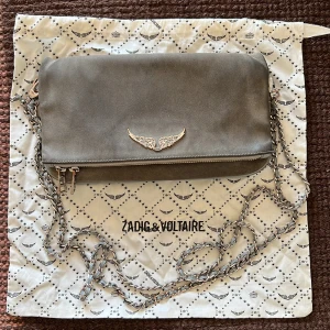 Grå Zadig & Voltaire Väska - Grå mockaväska från Zadig & Voltaire. Välanvänd men har mycket kvar att ge! Båda banden ingår ✨