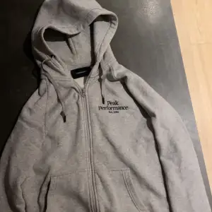 Grå peak perfomance hoodie som kostade 1300 kr när köpte. Väldigt skön och bra kvalitet.