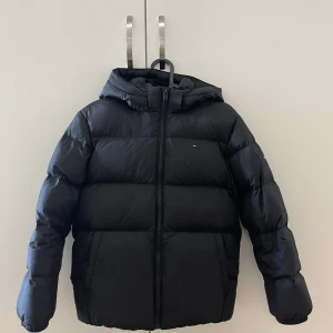 Vinterjacka  - Vinterjacka från Tommy Hilfiger, köptes i storlek 152 men passar även som XS, använd en vinter 