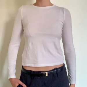 Tajt Långärmad Vit T-Shirt - Nästan aldrig använd vit långärmad T-shirt i 95% bommull från H&M.   Storlek: 146/152 - 12/14 år (passar som XS/S i damstorlek)