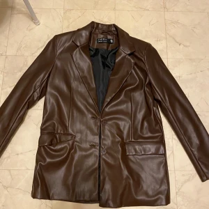 Vacker brun läder jacka  - Köpte den från New Yorker. Storlek 38 och passar för någon som är storlek S/M. Haft på mig jackan ungefär bara en gång och säljer den för att den var för stor på mig. Den har inga fläckar och är i helt nytt skick!