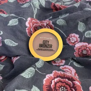 Säljer en Maybelline City Bronzer i nyansen Light-Warm 150. Perfekt för att skapa en naturligt solkysst look med en mjuk kontur. Den kommer i en praktisk rund förpackning med ett genomskinligt lock, så du enkelt kan se färgen. Superenkel att applicera för en fräsch och varm glöd!