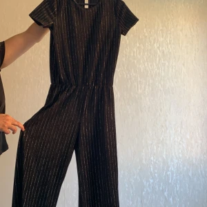 Byxdress  - I svart med glitter ränder i storlek 158  I bra skick använd en gång