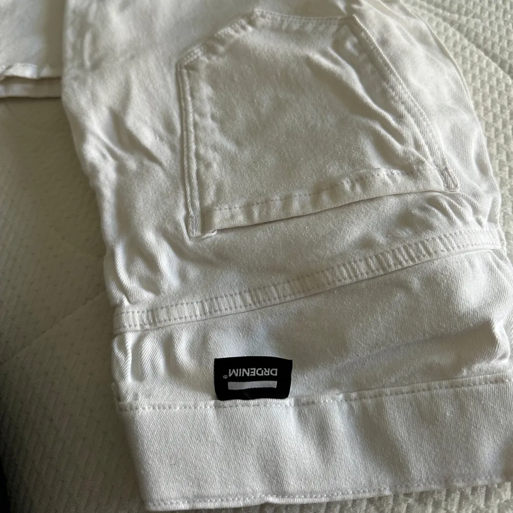 Säljer ett par snygga vita jeans från Dr.Denim. De har en klassisk femficksdesign med knappar och dragkedja framtill. Perfekta för en stilren look. Används 1 gång. Farkut & Housut.