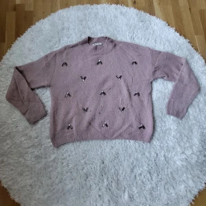 Ljuslila tröja med pärldetaljer från H&M - Säljer en superfin ljusrosa isch tröja från H&M med coola pärldetaljer. Tröjan är stickad och har långa ärmar, perfekt för höst och vinter💞 Två små hål på framsidan.