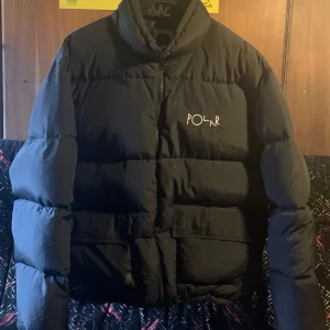 Svart pufferjacka från Polar Skate Co. - Säljer denna jacka åt min kille. Svart pufferjacka från Polar Skate Co, i storlek XL. Bra skick med några små fläckar.