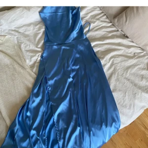 Balklänning - Blå balklänning med öppen rygg, köpte här på Plick men hittade en annan klänning så aldrig använd av mig. Använt skick, någon fläck men borde gå bort i tvätten.