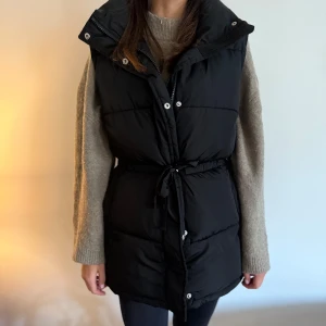 Dunväst XS svart - Som ny. Fina detaljer med spännband i midjan, något stor i storlek så passar även en S. 