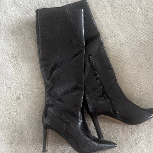 Boots med spetsig tå och krokodilmönster - Superfina bruna stövlar som är använda en gång! Perfekt till hösten🍂 Storlek 39 Klack höjd 8.7 cm Skaftomkrets runt vaden: 38 cm Skafthöjd: 41 cm Nypris 899 kronor