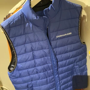 Calvin Klein Väst - Fin Calvin Klein väst använd ett fåtal gånger.  OBS LITEN DEFEKT! (Syns på bilderna) Äldre model. DM vid funderingar!🙂