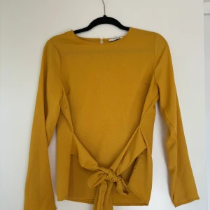 Blus - Oanvänd senapsgul blus med knytning, strl. S