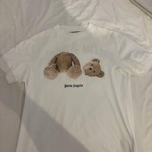 Vit Palm angels Teddy t-shirt. Endast använd några få gånger. Toppskick! Köpt på Farfetch ny för ca 2400kr. Storlek S. Passar även M eftersom den är oversized.