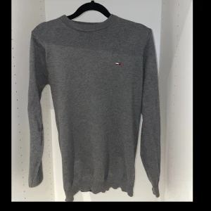 Grå tröja från Tommy Hilfiger - Säljer en stilren grå tröja från Tommy Hilfiger. Den är i normal passform och har långa ärmar. Perfekt för både höst och vinter. Tröjan har en liten broderad logga på bröstet. Superbekväm och lätt att matcha med allt!