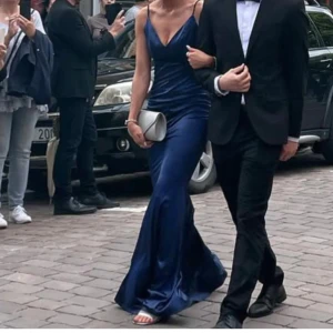 Mörkblå långklänning med öppen rygg - Elegant mörkblå långklänning med smala axelband och v-ringning. Endast använd 1 gång, skriv för mer bilder mm💕