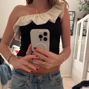 Svart offshoulder topp med volang - Trendig svart offshoulder topp med vita volanger!! Perfekt inför sommaren samt till olika typer av sammanhang, kommer tyvärr ej till användning längre därav säljer jag🥰🥰