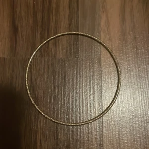 Guldfärgat armband  - Säljer ett guldfärgat armband då jag haft det länge men det kommer inte till användning för mig. Vet tyvärr inte vart jag köpte detta armband! Armbandet är hårt och går därför inte att stretcha eller justera storlek på. 