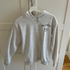 Grå hoodie med tryck ma chérie - Säljer en grå hoodie med texten 'MA CHÉRIE' som är väl använd men omhändertagen💓
