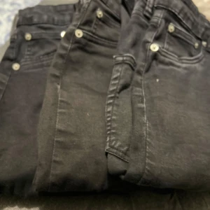 Svarta jeansbyxor från Lager 157 - Snygga svarta jeansbyxor med klassisk femficksdesign och silverfärgade knappar. Märket snake Perfekta för en stilren look. Två st i storlek M och 1st i strl S