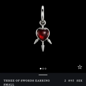 Three of Swords örhänge - INTRESSEKOLL!Snyggt örhänge från Maria Nilsdotter,med ett rött hjärta i mitten och tre svärd som sticker ut. Tillverkat i silver med en elegant design som ger en unik touch. Perfekt för att ge din stil en edgy känsla. (Singel)