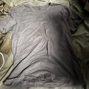 Svart t-shirt från Hugo Boss - Snygg svart t-shirt från Hugo Boss med diskret broderad logga på bröstet. Perfekt för en stilren look. Tillverkad i mjukt material för extra komfort.