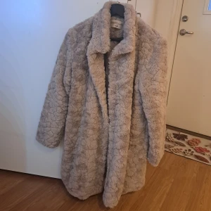 Beige teddyjacka från Mywear - Mysig beige teddyjacka från Mywear i storlek M. Jackan har en fluffig textur och långa ärmar, perfekt för kyliga dagar. Den har en klassisk krage och stängs med dolda knappar framtill. Oanvänt för att det är liten för mig. 