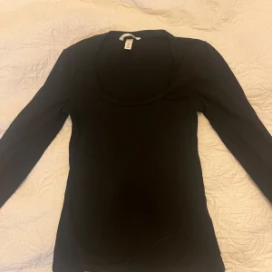 Svart Långärmad topp - Svart långärmad topp med urringning från H&M. Använd ca 1 gång. Storlek S. Super fint skick nästan som ny! Klicka gärna på köp nu🥰