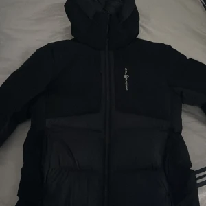 Svart dunjacka från sail racing  - Säljer en svart dunjacka från sail racing Jackan har en praktisk huva och dragkedja framtill. Perfekt för vintern. HELT NYSKICK säljer pga har en ny jacka