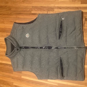 Grå moncler väst - Fin best i otroligt bra skick, säljes då jag inte använder den längre. 100 procent äkta
