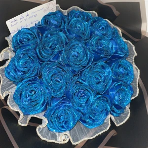 Eviga rosor  - En vacker bukett med glittrande blå rosor, inslagna i elegant svart och beige papper. Buketten är dekorerad med ett blått sidenband.💙