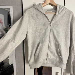 Grå hoodie med dragkedja från 157 - Mysig grå hoodie från lager 157, en fläck på framsidan därav priset.