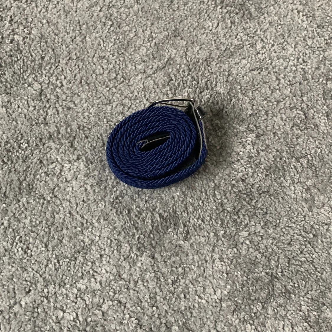 Blått bälte med silverfärgat spänne