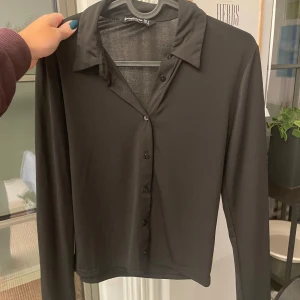 Svart skjorta från Stradivarius - Snygg svart skjorta från Stradivarius i storlek M. Skjortan har långa ärmar och knappar framtill, perfekt för en stilren look.