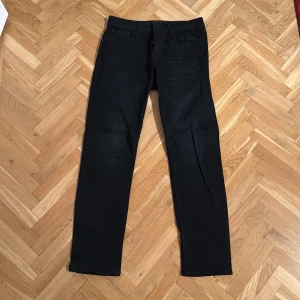 Svarta jeans från Jack & Jones - Använda en gång och passar inte längre. Snygga svarta jeans från Jack & Jones med en komfortabel passform. De har en klassisk design med fem fickor och en dragkedja. Perfekta för en stilren look.