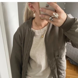 Grön bomberjacka khaki oliv grön - Snygg olivgrön bomberjacka med dragkedja och ribbade muddar. Perfekt för en casual look och enkel att matcha med olika outfits.