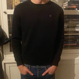 Svart tröja från G-Star RAW - Säljer en stilren svart tröja från G-Star RAW. Tröjan har en enkel design med rund hals och långa ärmar. Perfekt för en avslappnad look.