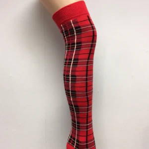Röda knästrumpor med rutigt mönster - Snygga röda knästrumpor med ett klassiskt rutigt mönster i svart och vitt. Perfekta för att ge en färgklick till din outfit. Strumporna är bekväma och passar bra till både vardag och speciella tillfällen.