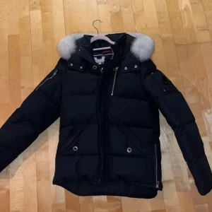 Mörkblå dunjacka Moose Knuckles - Säljer en svart dunjacka från Moose Knuckles. Perfekt för kalla vinterdagar. Storlek M, använd 5-10 gånger under en vinter sen bara hängt i garderoben