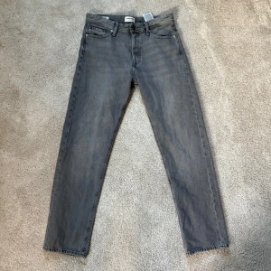 Gråa Jack & Jones jeans - Säljer ett par snygga helt nya grå jack & jones jeans av den populära och trendiga modellen chriis. Nypris 900kr. Säljer nu dem för endast 399kr. Först till kvarn, skriv vid frågor!