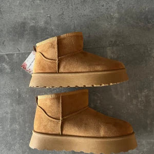 Bruna vinterskor från Claudia Ghizzani - Bruna Ugg platform liknande vinter/höst/vårskor från Claudia Ghizzani. Strl 36. Helt nya och oanvända med alla lappar och kartong kvar.