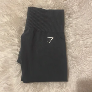 Grå leggings från Gymshark - Snygga grå leggings från Gymshark med hög midja och ribbad detalj. Köpte dessa för ca 550kr,  kanske ett halvårs sen, har aldrig använt dom, och nu är de för små för mig💞 Storlek xxs 