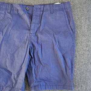 Blå shorts från Hampton Republic - Snygga blå shorts från Hampton Republic med knapp och dragkedja framtill. Perfekta för en avslappnad stil. De har två bakfickor med knappar och är tillverkade i ett bekvämt material.