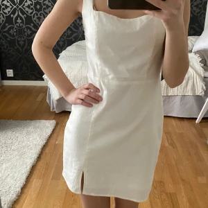 Studentklänning - STUDENTKLÄNNING👩‍🎓🌸Stilren design, i linneblandning med en slits framtill. Lite åt det naturvita hållet i färgen. Helt ny med lappen kvar!